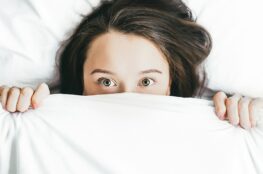 woman covering her face with blanket